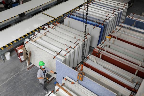A worker arranges slabs in the factory at IceStone, a manufacturer of recycled glass countertops and surfaces, in New York City