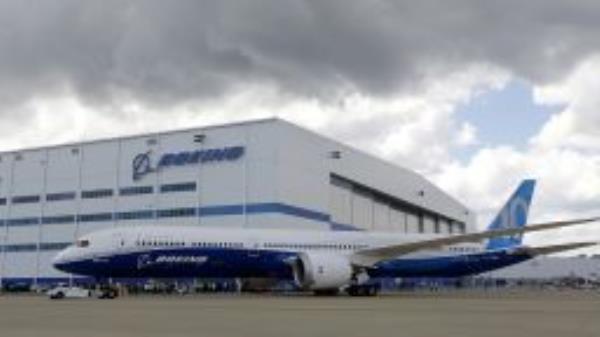 In this Friday, March 31, 2017, file photo, Boeing employees stand near the new Boeing 787-10 Dreamliner at the company's facility in South Carolina after conducting its first test flight at Charleston International Airport in North Charleston, S.C. 