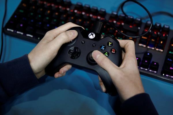 An attendee uses a Microsoft Xbox One controller while playing a video game at the Paris Games Week (PGW), a trade fair for video games in Paris, France, October 29, 2019.