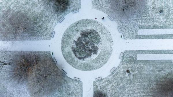 People walk in the gardens of St Nicholas' Park after overnight snow showers in Warwick. Parts of the UK are being hit by freezing conditions with the UK Health Security Agency (UKHSA) issuing a Level 3 cold weather alert covering England until Monday and the Met Office issuing several yellow weather warnings for snow and ice in parts of the UK over the coming days. Picture date: Sunday December 11, 2022.