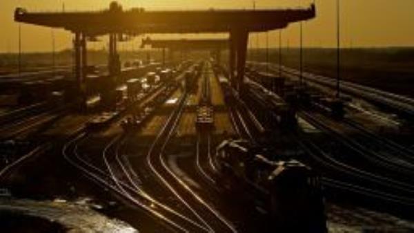 Shipping containers are offloaded at a BNSF Railway intermodal facility as the sun sets in Edgerton, Kan.  (AP Photo/Charlie Riedel, File)