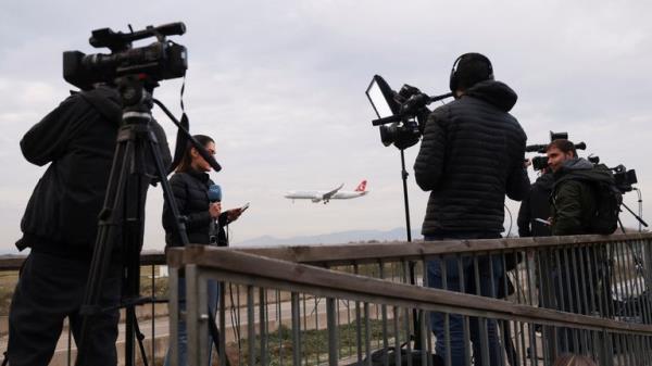 Journalists gather after a commercial airplane flying from Morocco to Turkey made an emergency landing in Barcelona's El Prat airport in the early hours and 28 would-be migrants on board ran away across the tarmac in Barcelona, Spain December 7, 2022. REUTERS/Nacho Doce REFILE - QUALITY REPEAT
