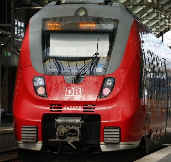 A woman with a bike stands on a platform next to a Deutsche Bahn train during a nationwide strike of Germany's train drivers union GDL at Ostbahnhof train station in Berlin