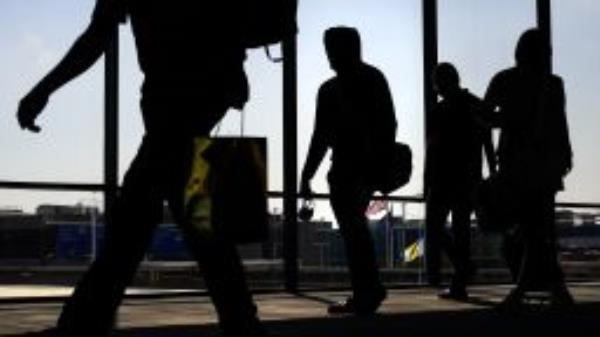 File - Arriving passengers move toward the baggage claim area at Philadelphia International Airport in Philadelphia on Friday, July 1, 2022. Travelers will probably pay more for airline tickets or a hotel room around the holidays than they did over last Thanksgiving or Christmas. (AP Photo/Matt Rourke, File)