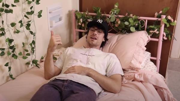 Caleb Simpson tests out a renter's bed during an apartment tour.