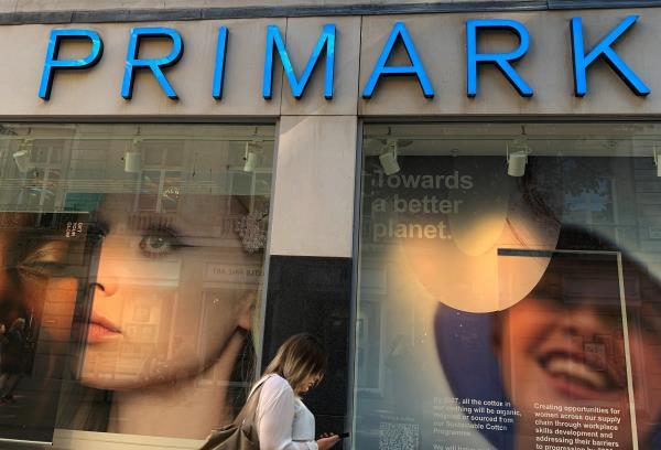 A woman walks past a window display at a Primark store in Liverpool