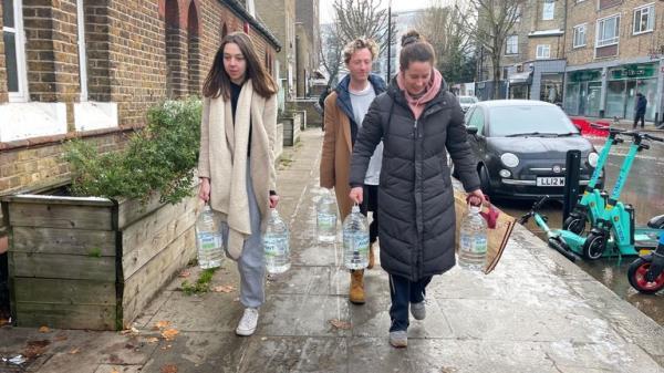 (L to R) Emma Thompson, Nick Carragher and Sophie Adams, were returning home to the flat they share close to the flood carrying 30 litres of water
