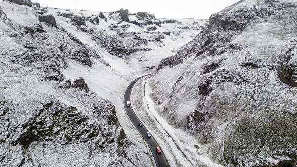 Cars negotiate Winnats Pass in the Peak District as snow and ice swept across parts of the UK, with cold wintry conditions set to continue for days. Picture date: Tuesday December 13, 2022.
