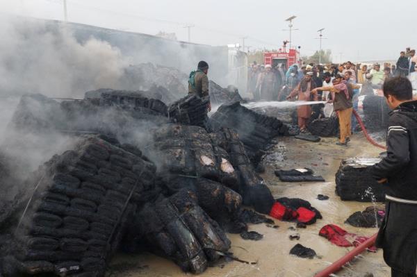 FILE PHOTO: People douse a cargo supply truck after it was hit during the artillery shelling, in the Pakistan-Afghanistan border town of Chaman, Pakistan, December 11, 2022. REUTERS/Abdul Khaliq Achakzai/File Photo