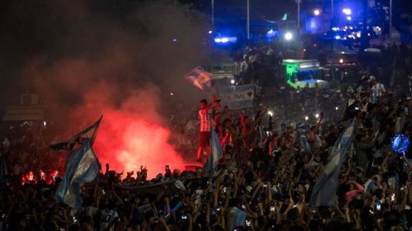 Crowds cheer and wave flags as they welcome home players after the World Cup win. Pic: AP 