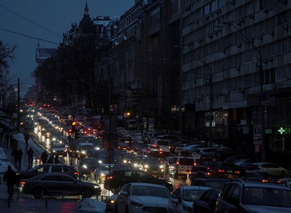 Cars are seen at a street during a power blackout after critical civil infrastructure was hit by Russian missile attacks in Kyiv