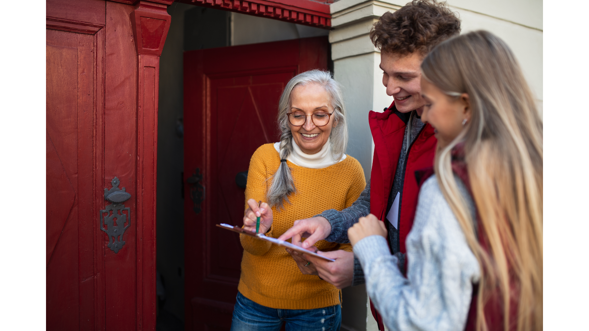 happy young people and happy old person looking at documents on red door step 